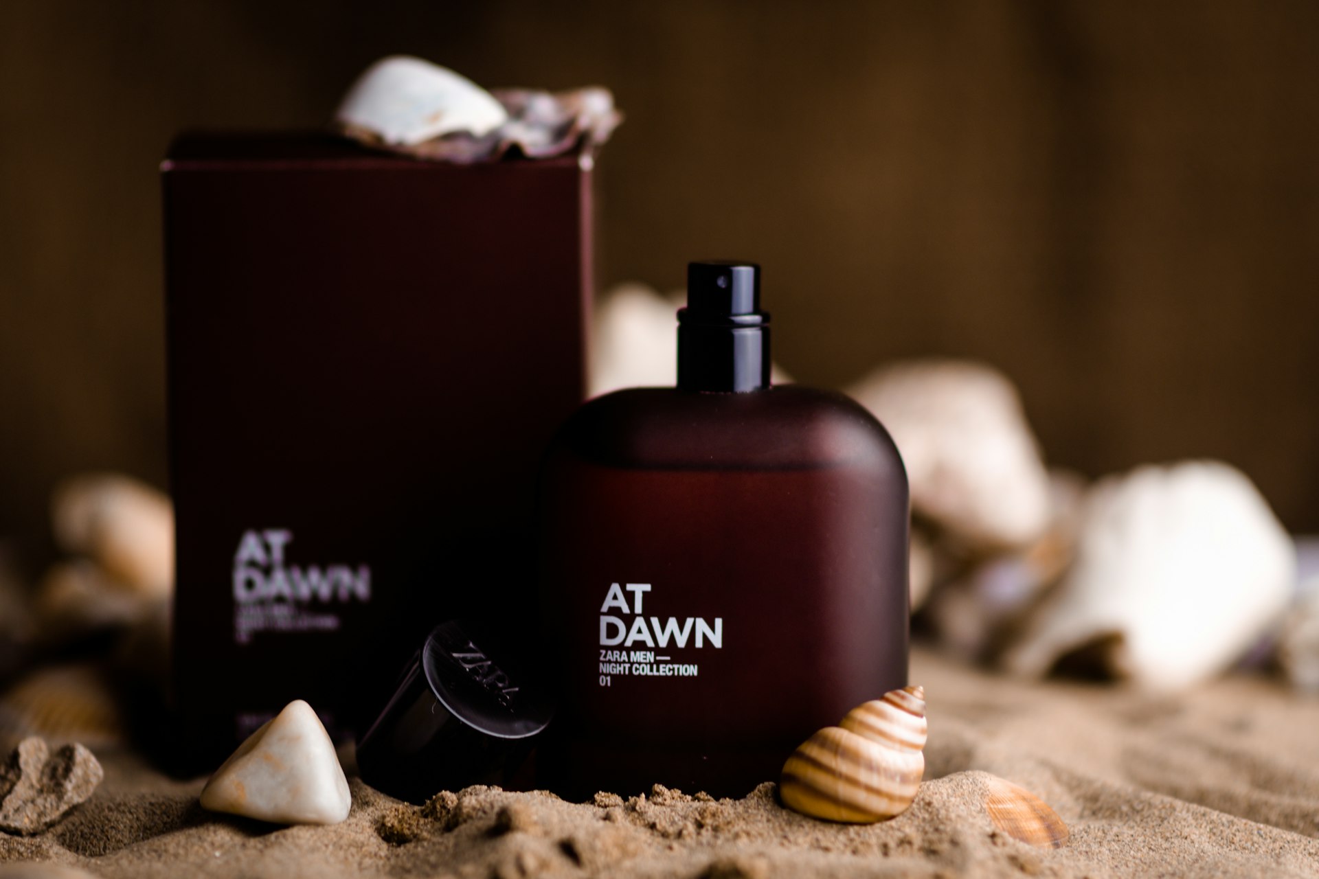a bottle of at dawn next to a box of shells